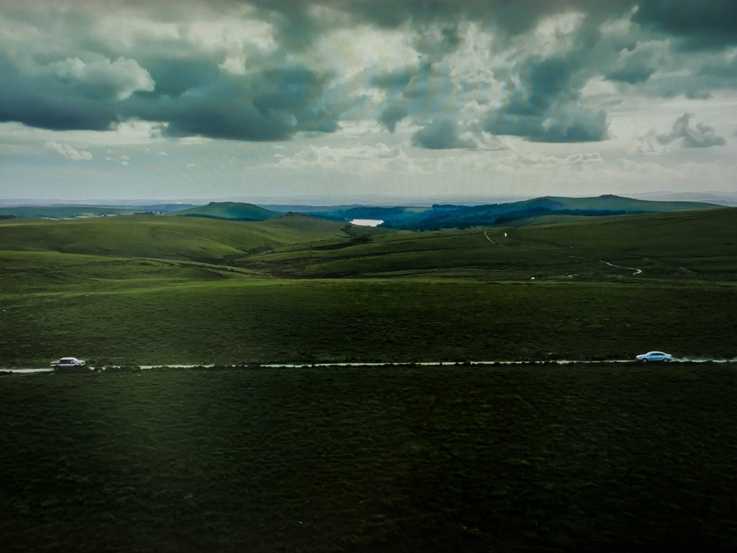 The Devil's Hour - Amazon MGM - Scene An aerial shot of two cars heading towards each other at high speed in Dartmoor on a single track lane.
